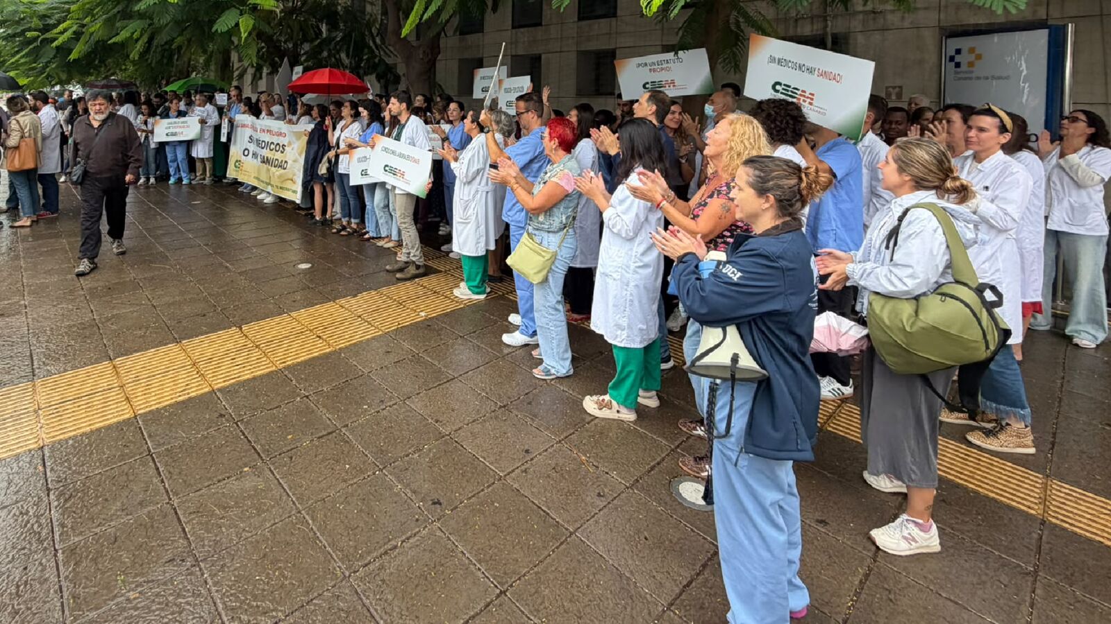 Médicos y pacientes aplauden en fila junto a la entrada de un centro del Servicio Canario de la Salud